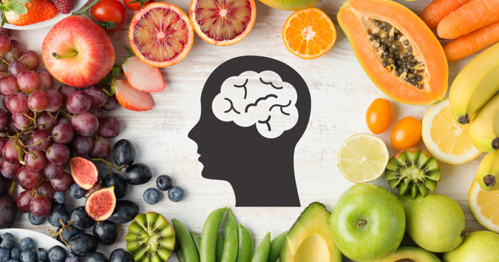 A silhouette of a human head with a brain illustration, surrounded by fresh fruits and vegetables, representing the connection between nutrition and mental health.