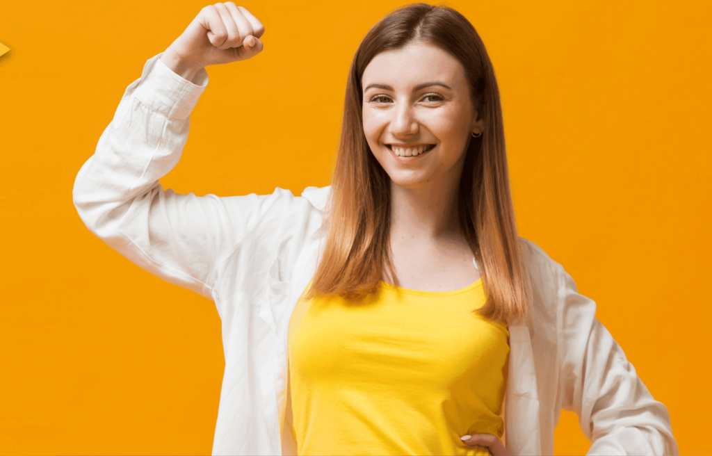 Confident woman flexing her arm, symbolizing women’s health and empowering women’s wellness with strength and vitality